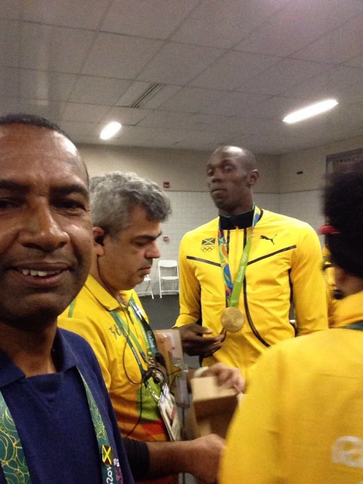 Capellán voluntario adventista (izquierda) se fotografía con Bolt en la Villa Olímpica. Al fondo, Usain Bolt. 